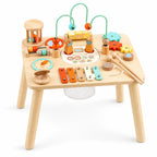 Meisje speelt met houten activiteitentafel met kralenbaan en xylofoon